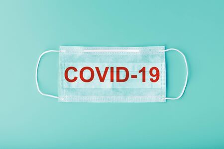 Medical masks for protection against dangerous coronavirus infection with the inscription COVID-19. Lack of protective face masks in the pharmacy. Isolate on a blue backgroundの写真素材