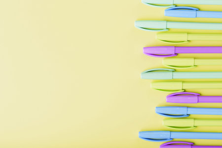 Multi-colored markers on a yellow background with free space. Minimalistic conceptの写真素材