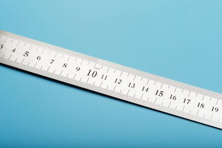 A metal ruler with a scale on a blue background is a superscape with a copy of the space for your text. Isolateの写真素材