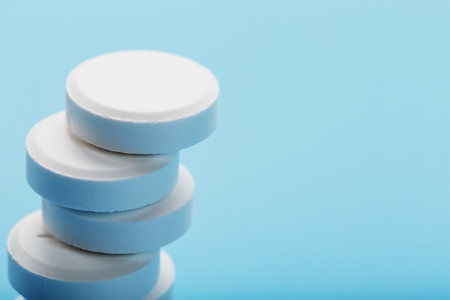 Tower of Medicinal tablets on a blue background, isolated. The view from the top, place for text.