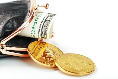 An open black wallet with money, dollars and bitcoin coins on a white background. Isolate, close-up, Studio light. Free space.の写真素材