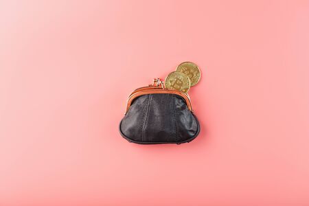 Classic black wallet with bitcoin coins on a pink background. Minimalistic concept. Free space, top viewの写真素材