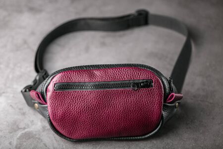 Waist bag made of dark red leather, banana on a gray background. Handmadeの写真素材