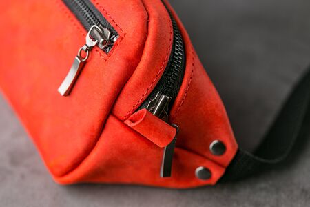 Red waist bag made of leather, banana on a gray background. Handmadeの写真素材