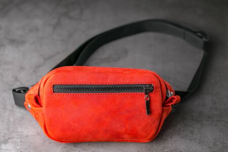 Red waist bag made of leather, banana on a gray background. Handmadeの写真素材