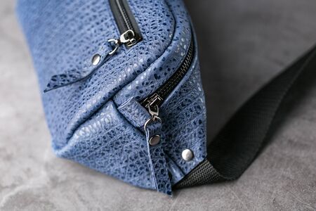 Waist bag made of blue leather, banana on a gray background. Handmadeの写真素材