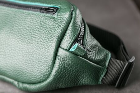 Belt bag made of dark green textured leather, banana on a gray background. Handmadeの写真素材