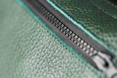 Zipper slider for a bag made of textured green leather. Handmade. Close up.の写真素材