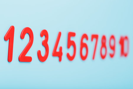 Red numbers on a blue background in a row from one to ten. Free space, top view
