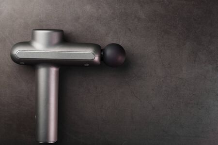 Electric massager for body massage on a black background. Universal device for improving the whole body, works on vibration technology.の写真素材