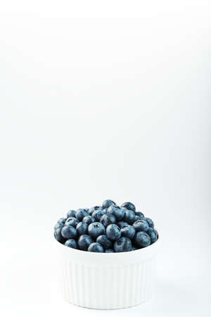 Juicy Blueberries in a white Cup on a white background.の写真素材