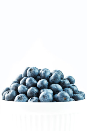 Blueberries are ripe berries in a white Cup on a white background.の写真素材