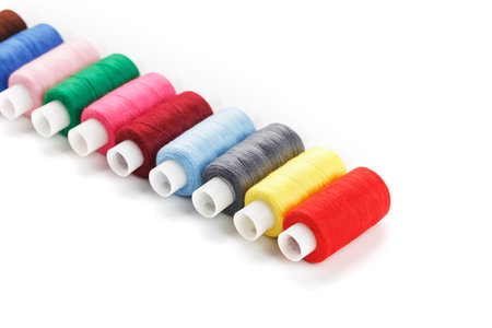 Sewing threads of different colors on reels on a white background. Free space, close-up. Isolate