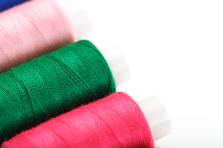 Colorful cotton craft sewing threads multicolored in a row isolated on a white background. Free...