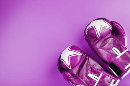 Pink Boxing gloves on a pink background, free space. The concept of dealing with difficulties. Feminism, the struggle for the diversity of personal and social rights for women.の写真素材