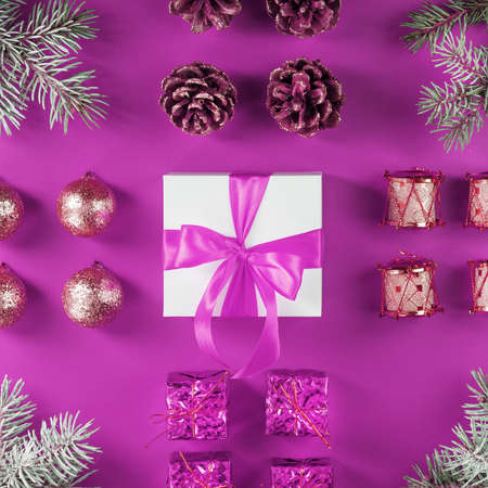 Gift in a white box and Christmas tree decorations on a pink background. Pink concept from christmas decorationsの写真素材