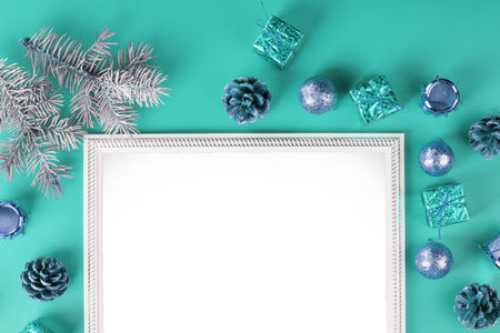 Photo frame with free white space around Christmas tree decorations and gifts on a blue background....