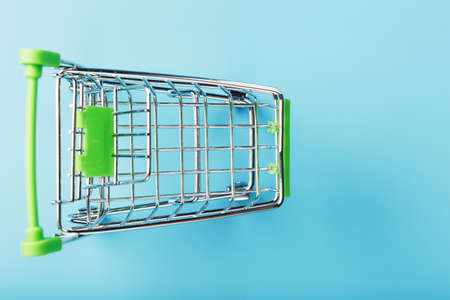 Supermarket shopping cart isolated on blue background. The concept of shopping. Copy the ad space. The view from the topの写真素材