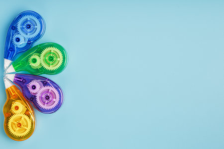 Stationery correction tapes are Multicolored on a blue background. Free space. The view from the top. Blue, green, yellow, lilacの写真素材