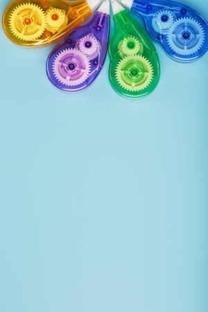 Multi-colored Stationery correction tapes on a blue background. Free space. The view from the top