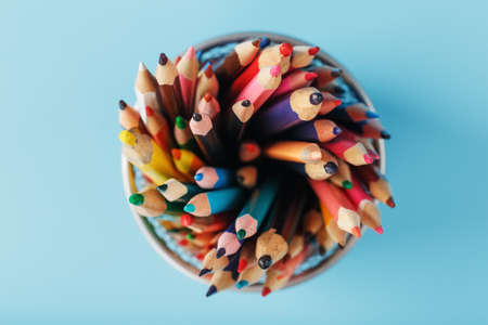 Colorful pencils in a metal jar on a blue background. The concept of creativity, the spaceの写真素材