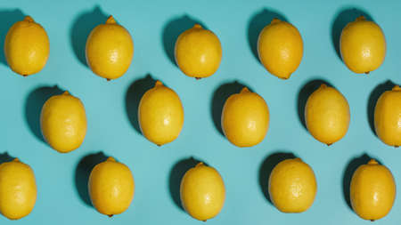 Yellow Lemon fruit patterns on a blue background, beautiful pattern. Top view, full screenの写真素材