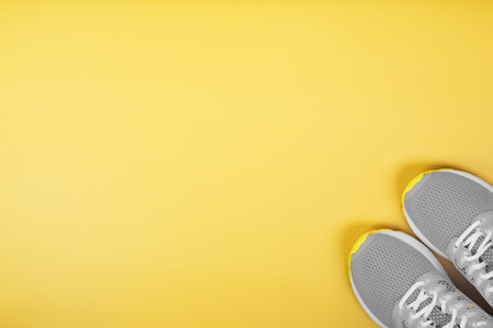 Sports gray sneakers on a yellow background - sport concept, free space. The trendy colors of 2021...