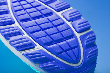 Fragment of the sole of a blue sneaker close-up. Textured texture of the material of sports shoes. Stylish shoes for running and training in the gym.の写真素材