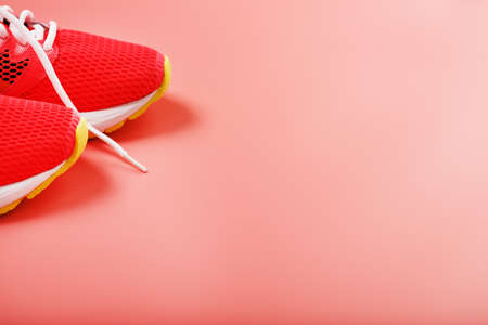 Jogging pink sneakers on a pink background with free space. Top view, minimalistic conceptの写真素材