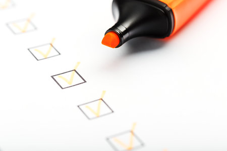Orange marker with markers on the checklist sheet. Checklist completed task concept.の写真素材