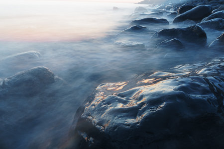 Sea water washing the rocks on the coast. A long-exposure shot of the seaの写真素材
