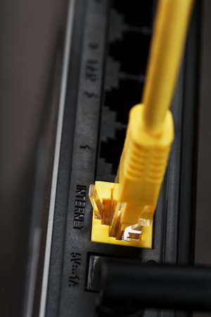 A yellow patch cord is inserted into the WiFi port of the router to access the Internet. Internet...