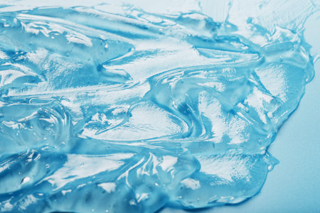 Antiseptic gel on a blue background in waves. The concept of antibacterial protection, cosmetics