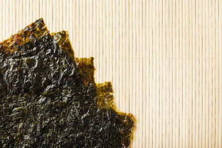 Nori algae leaves on a bamboo substrate. The main ingredient for sushi rolls. Top view