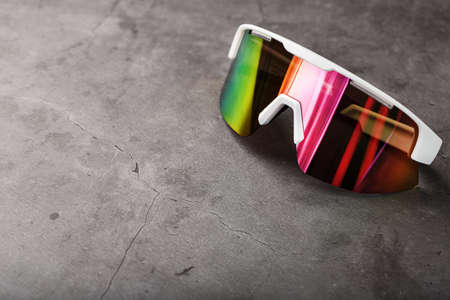 Sports glasses with a red mirrored lens and white frames on a black background. Free spaceの写真素材