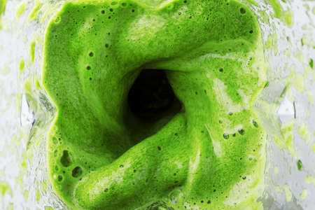 Green smoothie mixed in a blender bowl, top view. The concept of delicious and healthy food.の写真素材