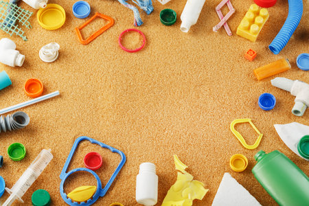 Discarded colorful plastic garbage from the ocean on the sand. Global environmental pollution. Free...