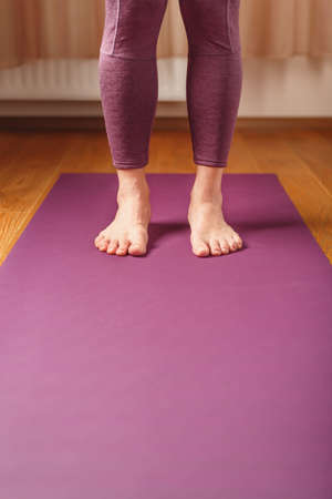Legs and hands of a woman on a yoga mat practicing asanas. A healthy lifestyle at home in isolation.の写真素材