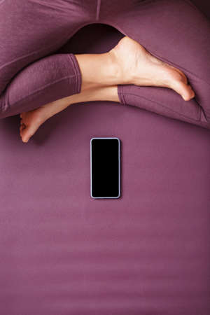 Yoga online training workout by smartphone, using the fitness app at home in the gym. Online yoga and meditation practices. Place on the smartphone screenの写真素材