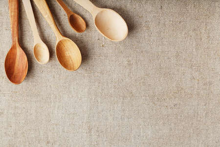 Wooden spoons made of natural wood on burlap fabric as a craft. Natural natural materials. Caring for the environmentの写真素材