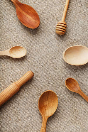 Natural wood spoons in a row on burlap fabric. Natural natural materials. Caring for the environmentの写真素材