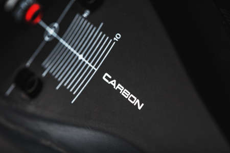 Carbon element of cycling shoes with the inscription CARBON on a black background close-up. Modern production technologiesの写真素材