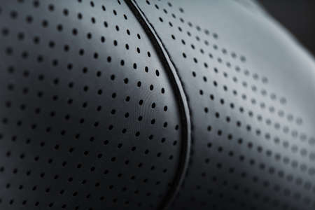 Full-screen close-up of black perforated leather. Texture material in macroの写真素材