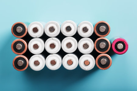 AA batteries are arranged in the form of a large battery on a blue background. Top view. The concept of energy supply and utilizationの写真素材
