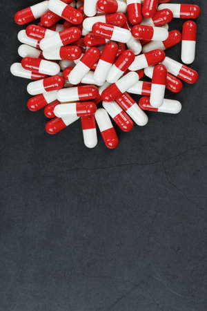 Pills with drugs are scattered on a black background. that is a dosed solid dosage form for oral administrationの写真素材