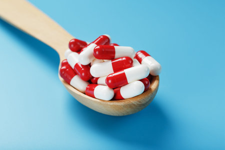 Red and white pill capsules on a blue background. Close-up of Free space Top view