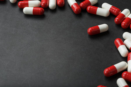 Pills with drugs are scattered on a black background. that is a dosed solid dosage form for oral...