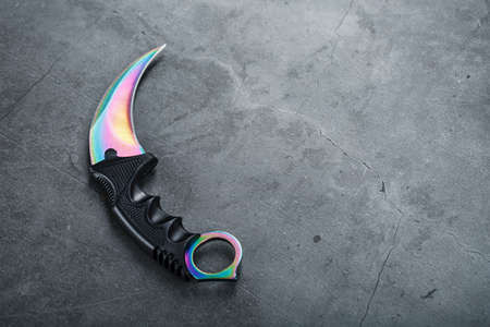 A dagger with a steel blade with a gradient color on a black background. Edged weapons, top view, free spaceの写真素材
