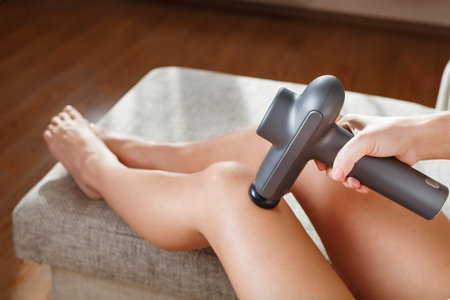 Massage of women's legs with a shock massage device. Shock self-massage to restore fascia muscles and trigger pointsの写真素材
