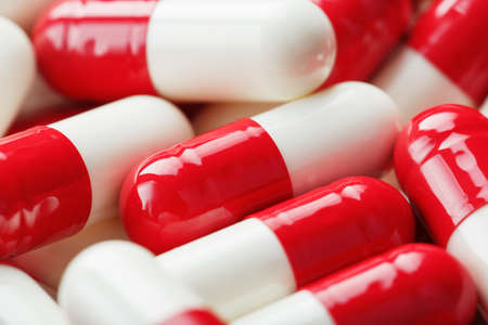 Red and white pills as a background in full screen. top view. Medicinal preparationsの写真素材